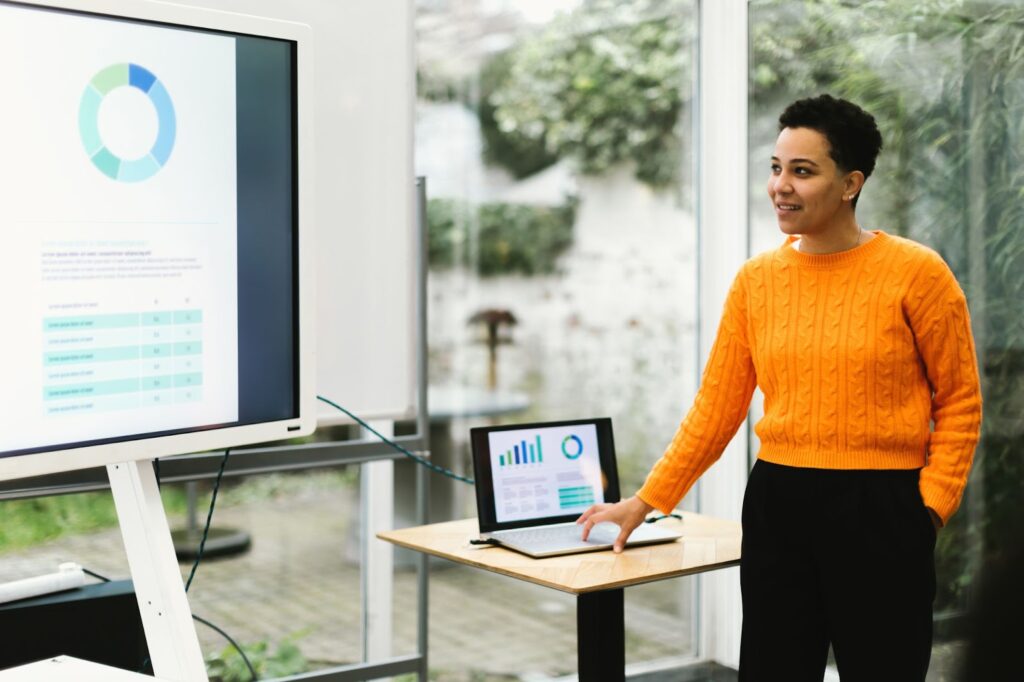A data engineer gives a business intelligence presentation and is analyzing data with graphs and charts. BigQuery on Google Cloud Platform helps businesses tap into their data.